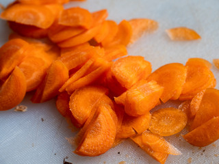 Slices of carrots on white plastic board