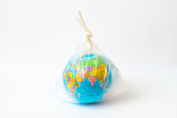 World Environment Day concept.Toy world globe in white plastic bag on white background.