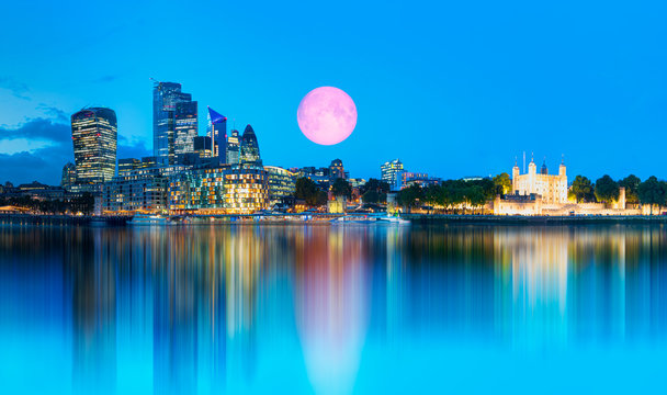 Panorama of the modern skyline on Thames river at twilight blue hour with full moon - London, United Kingdom "Elements of this image furnished by NASA"