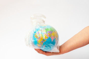  Image of human hand holds the planet earth in a white plastic bag over white background