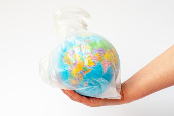  Image of human hand holds the planet earth in a white plastic bag over white background
