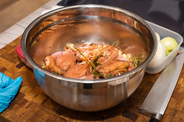 Pickled chicken with soy sauce and rosemary in a metal bowl. Marinade chicken fillet with different spices in its own juice