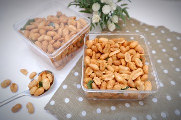 Kacang telur or egg peanut in a box with polkadot fabric with blurry background. Indonesian typical homemade crispy fried snack. Made from flour, eggs, nut, onion and lime leaf. Salty taste