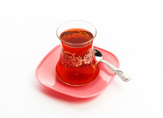 Turkish Tea in glass with pink plate. Isolated white background.