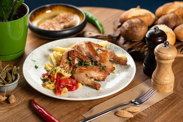 tobacco chicken with french fries, pickled pepper and microgreen on a wooden table. close-up