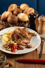 tobacco chicken with french fries, pickled pepper and microgreen on a wooden table. close-up