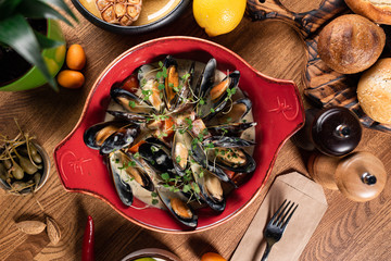 mussels in a creamy sauce with microgreens on a wooden table. top view