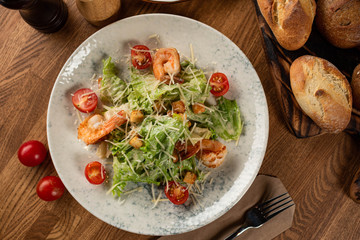 Caesar salad with chicken on a wooden table. top view
