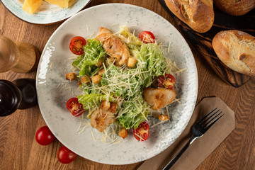 Caesar salad with chicken on a wooden table. top view