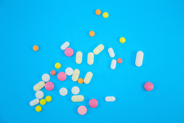 scattering of medical colorful pills on blue background