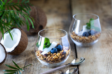 Two glasses of healthy breakfast: muesli with fresh blueberries, coconut and mint