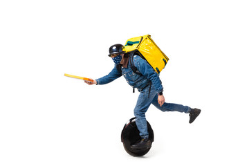 Too much orders. Contacless delivery service during quarantine. Man delivers food wearing gloves and face mask isolated on white. Taking pizza on unicycle isolated on white background. Safety. © master1305