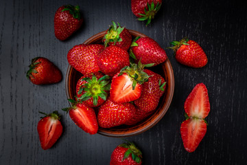 Ripe red strawberries on black background. Top view