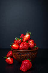 Bowl of strawberries on concrete dark background 