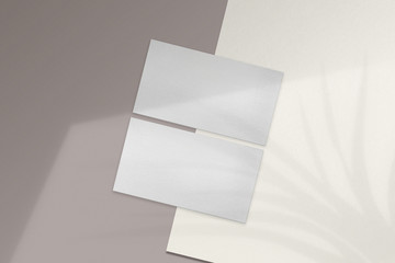 Clean minimal business card mockup on white paper and brown background. PSD file.