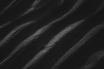 Fototapeta na wymiar Sand waves in black and white with contrasting shadows.