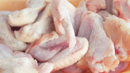 Fresh chicken wings in a plate on a white marble table with copy space. Raw chicken wings on a...