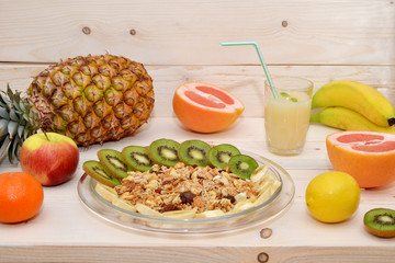 healthy breakfast of granola and different fruits on a wooden background