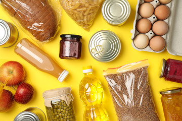 Different food on yellow background, top view. Donation concept