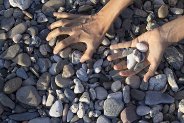 Woman hands touching stones on the beach