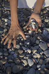 Woman hands touching stones on the beach