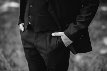 Hands of a man in the pockets of his trousers close-up
