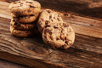 Chocolate cookies on wooden table. Chocolate chip cookies shot on vintage background