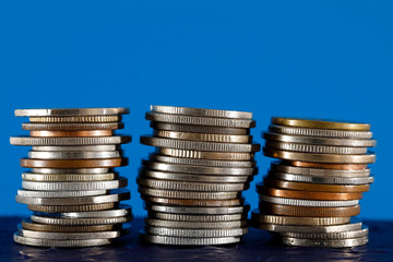 Piles of various coins is on blue background