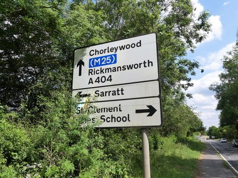 Road sign on the A404 in Hertfordshire with directions to Chorleywood, the M25 motorway, Rickmansworth, Sarratt and St. Clement Danes School