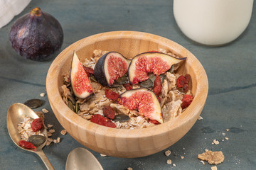 Granola for healthy breakfast. Bowl with granola , milk , fresh fig and dried berries