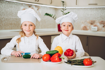 little cooks cut vegetables for salad