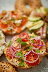 Assortment of different kinds toppings homemade bagels sandwiches with sesame and poppy seeds