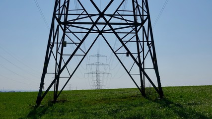 Stammst hinter Strommast auf freiem Feld