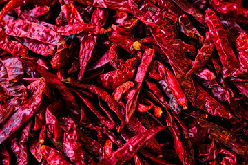 Dried dry red spicy chili peppers pile at asian market close up texture background. Sardar Market,...