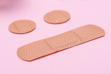 Set of adhesive bandage, medical sticking plaster on pink background