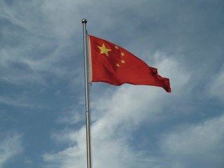the chinese flag with clouds behind