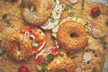 Tasty colorful various bagels with healthy ingredients served on brown baking paper