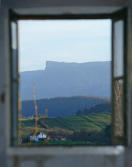 A frame in a frame shot shot of field and mountains through a window