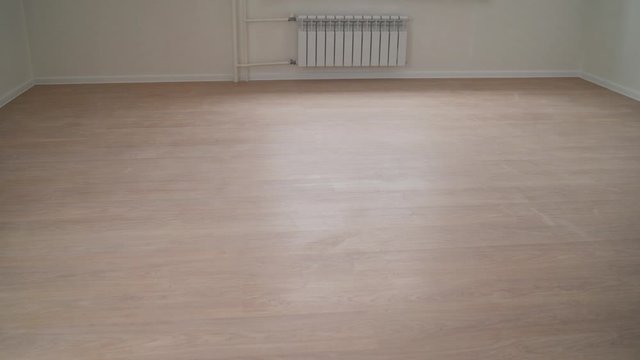 empty room after renovation- two windows, white walls and wooden floor in new apartment. New laminate in a new apartment