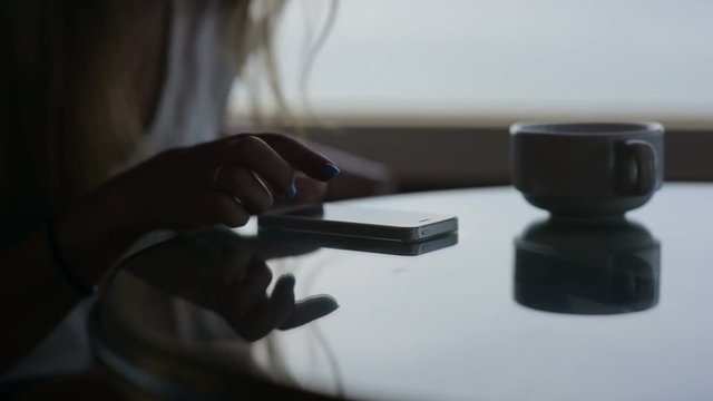 close up hands of young beautiful girl sits in a cafe with panoramic view. Morning with a cup of coffe, tea, book, notepad, reading, wrighting, drinking, communicate, use smrt phone