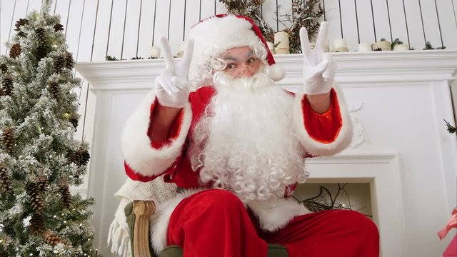 Santa Claus showing a victory sign with both hands