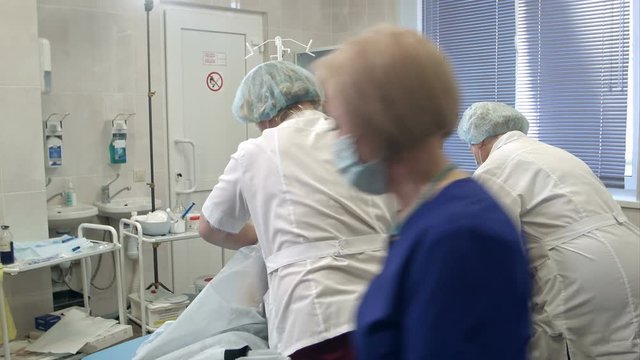 Team of doctors and nurses preparing patient for gastroscopy