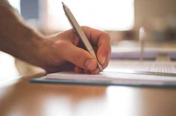 close up of hand writing on a notebook
