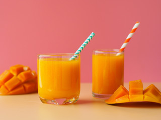 Mango juice on pink color background for summer party drinks concept.