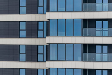 Obraz premium part of the facade of a modern residential building. Modern architecture made of glass and concrete.