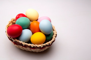 Fototapeta na wymiar Multicolored Easter eggs in a basket on white background.