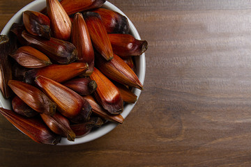 Bowl of pine nuts on the wooden table. Top View