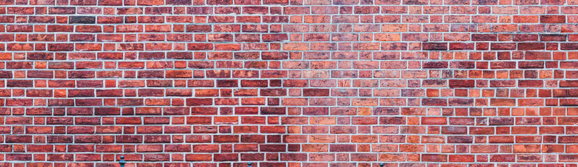 Panoramic red brick wall as texture background. Flat wall surface of an old building.