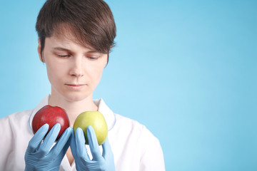 Portrait of a woman doctor who holds two red and green apples in her hands. recommendations for proper nutrition