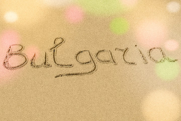 Bulgaria title on the light sand beach near the black sea coast. Bokeh falls on the letters.